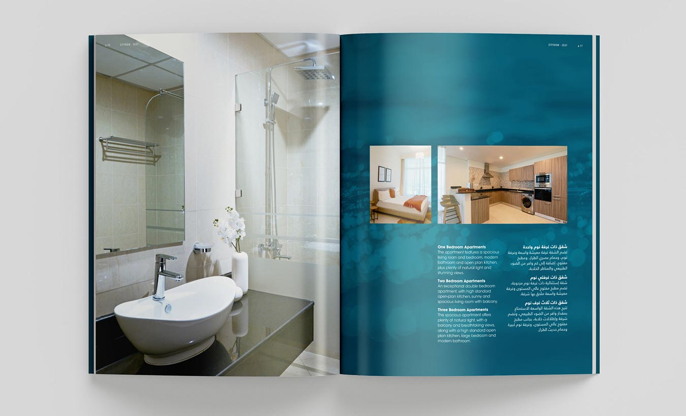 An open real estate brochure spread featuring a full-page photo of a modern bathroom with a white vessel sink on the left, beside a teal-colored right page showcasing two inset photos of a bedroom and kitchen with bilingual text.
