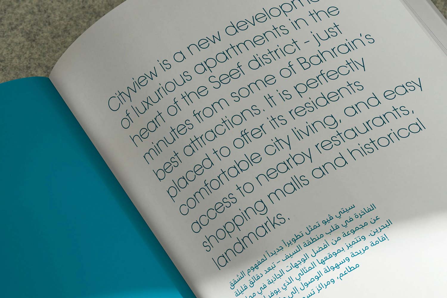 A close-up shot of an open brochure page displaying large introductory text about Cityview apartments in both English and Arabic.